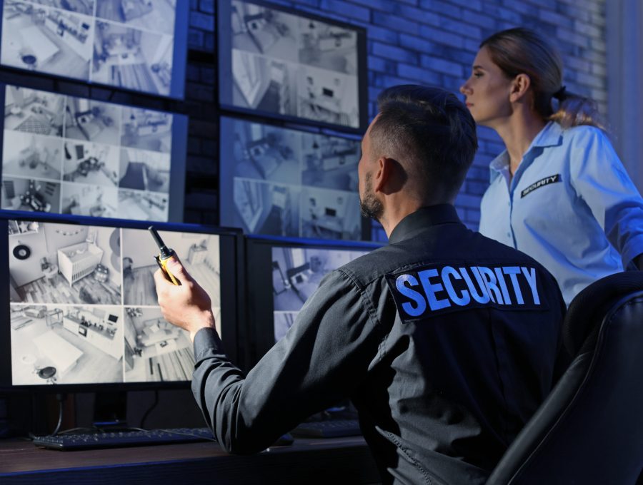 Security guards monitoring modern CCTV cameras indoors