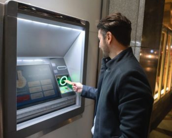 Man withdrawing money at a cash point in the streets of New York