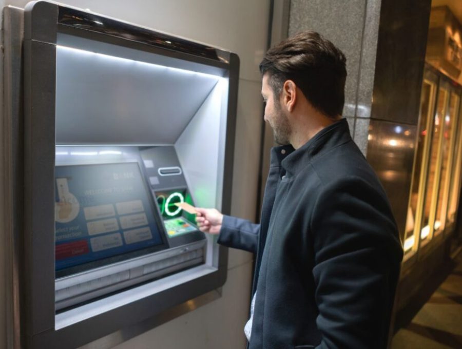 Man withdrawing money at a cash point in the streets of New York